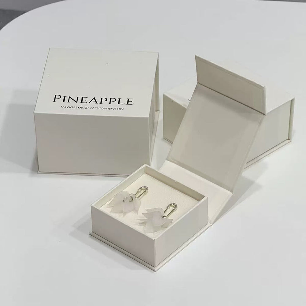 Open book-style magnetic jewelry box with a fitted interior