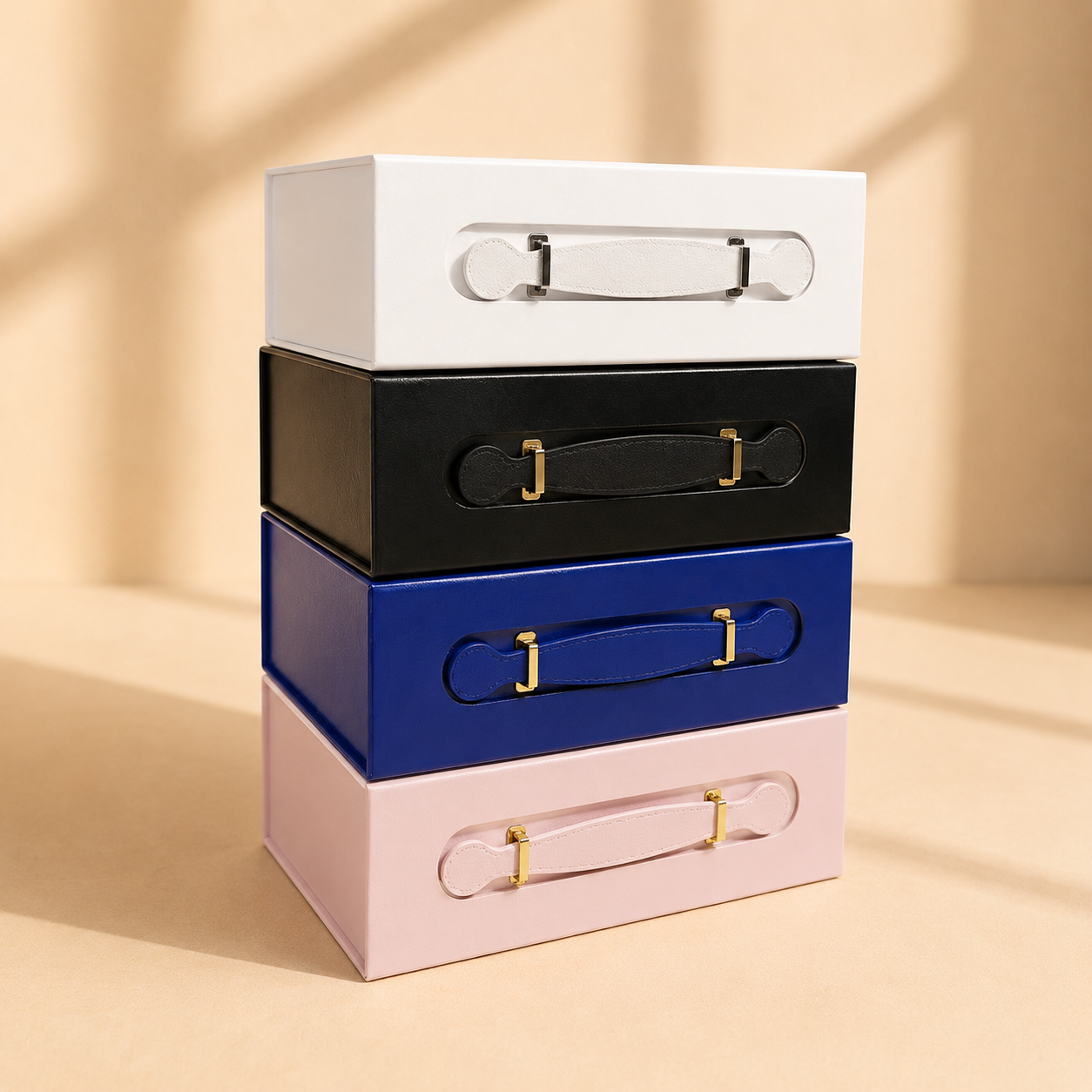 Stack of handled folding gift boxes in white black blue and pink