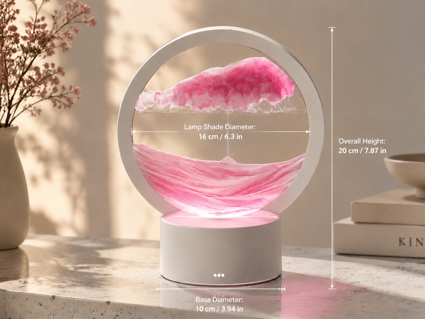 A circular 3D moving sand art lamp with soft pastel pink and white sand grains gracefully cascading down to form a majestic mountain range, illuminated by its warm built-in LED base.