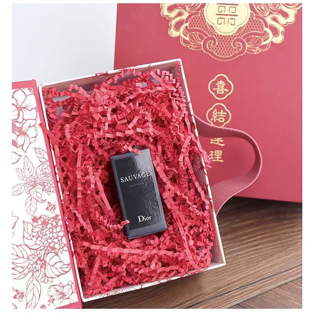 Red crinkle paper filler arranged in an open gift box