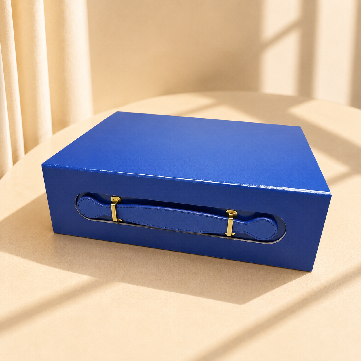 Blue handled folding gift box with ribbon handles and gold hardware