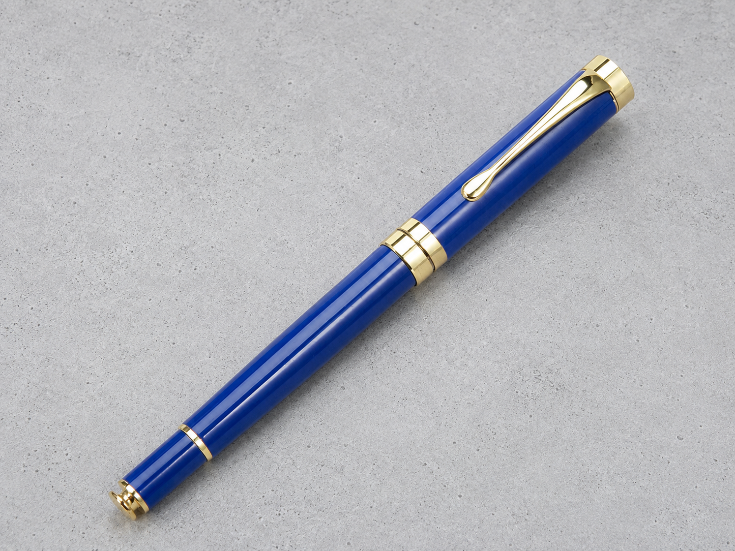 Luxury royal blue metallic gel pen with high-gloss finish and a gleaming gold clip for signing documents.