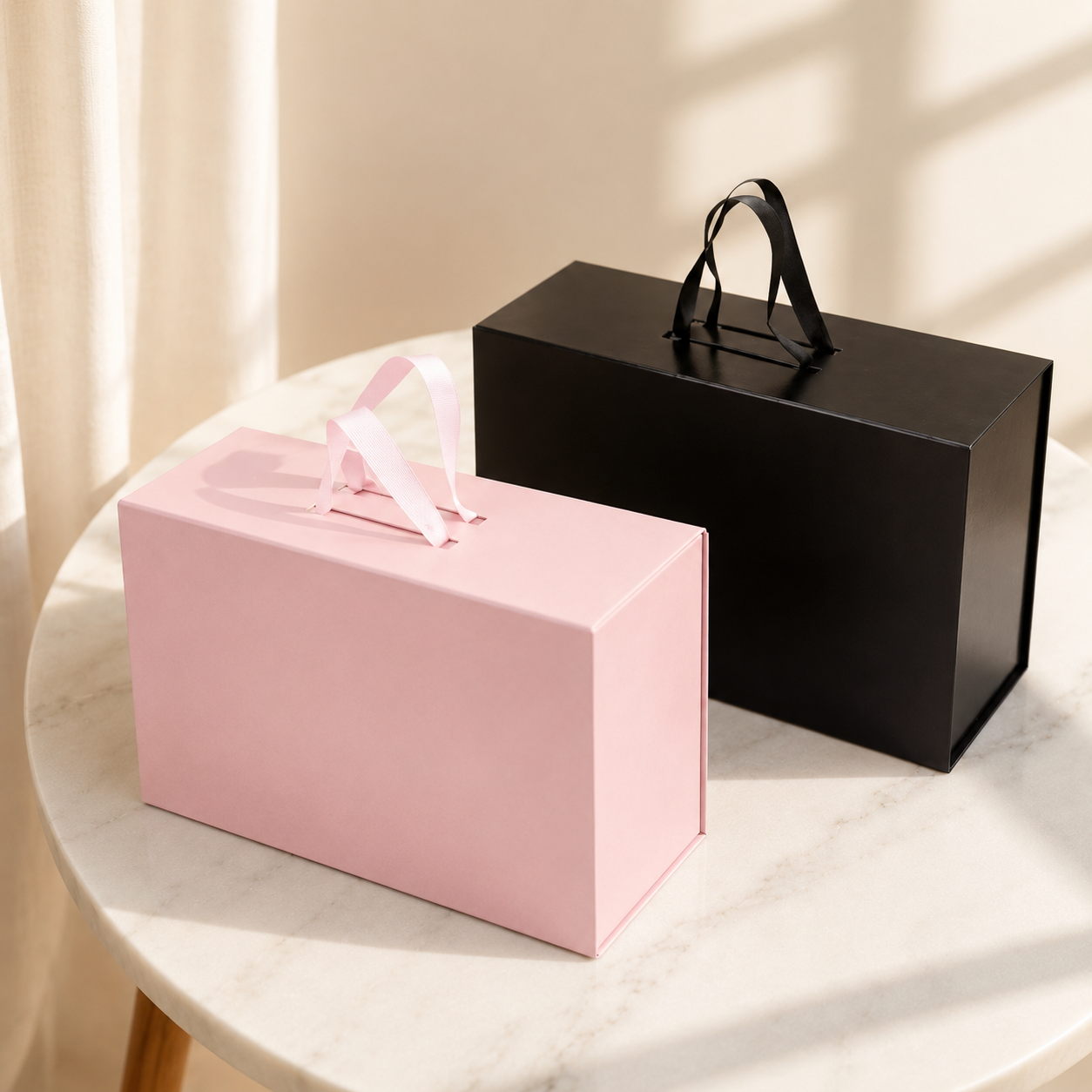Pink and black handled folding gift boxes on display