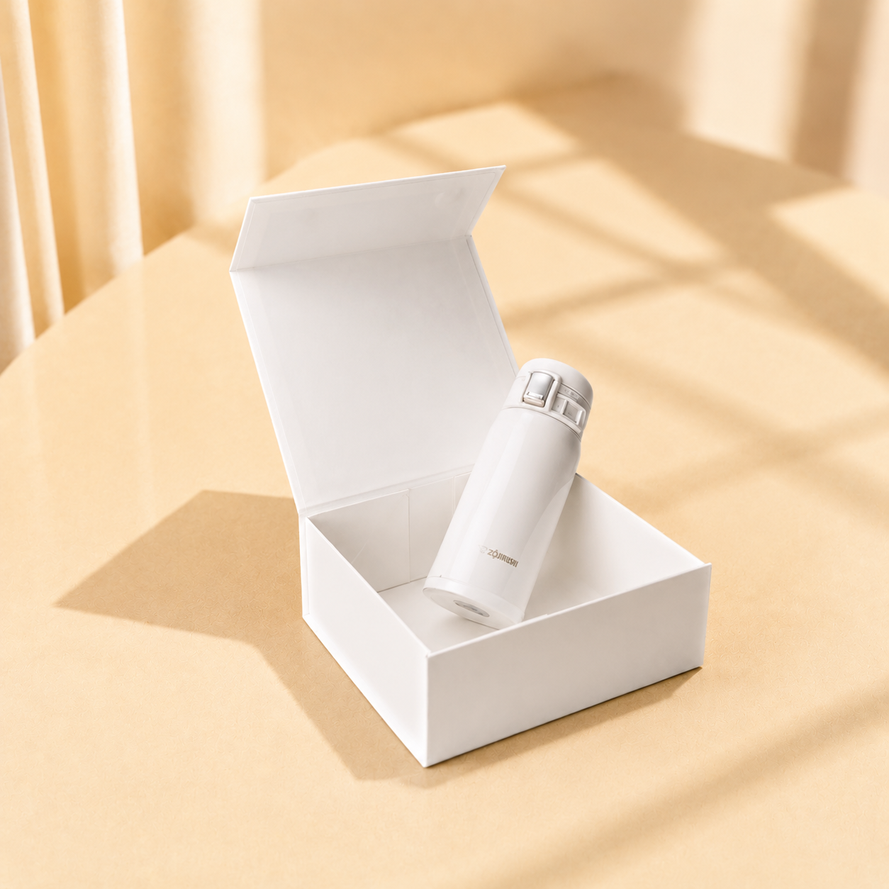 Open white jewelry gift box holding a small bottle